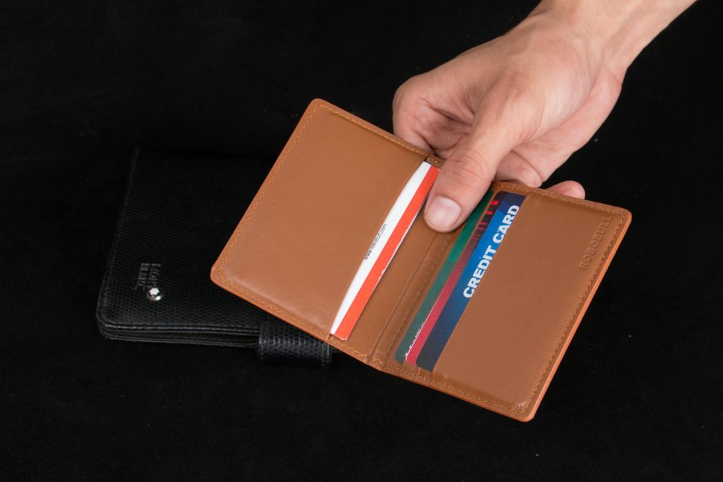 hand holding brown leather card holder
