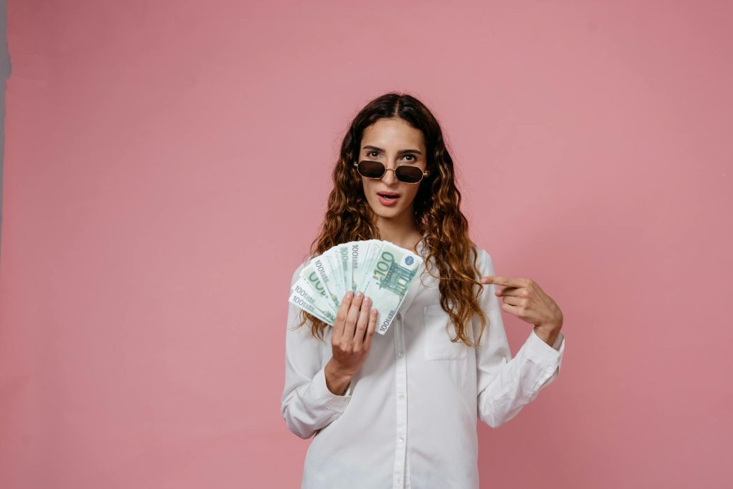 woman holding cash money