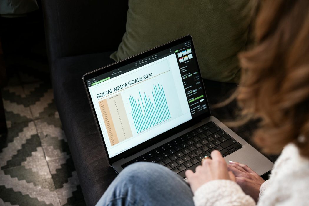 woman sitting on a sofa with a laptop displaying a chart