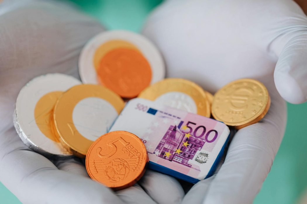 anonymous doctor showing money wearing gloves