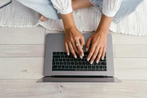 crop woman typing on laptop